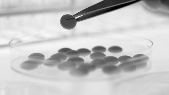 Scientist lifting pill from petri dish with tweezers. Image shot 2009. Exact date unknown.